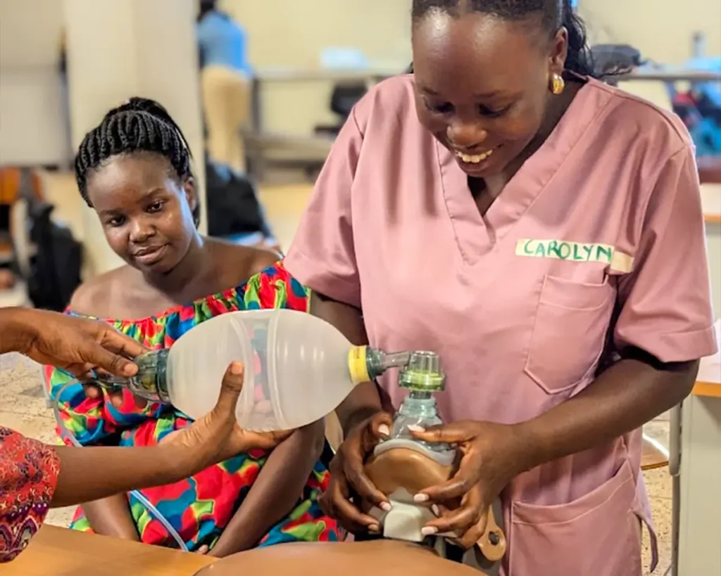 A healthcare provider is seen practicing ventilation using the Laerdal Bag-Mask-Ventilator on a Little Anne training manikin.