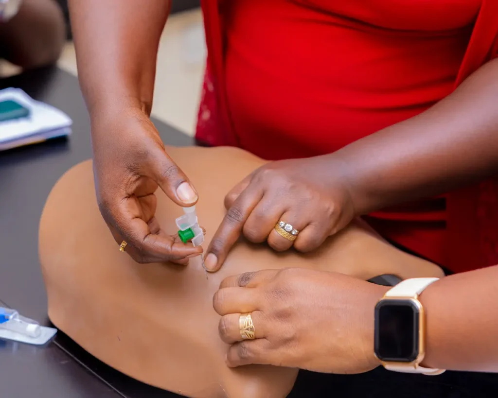 Close-up image showing the Needle Decompression Trainer being used to practice needle decompression thoracostomy (NDT).